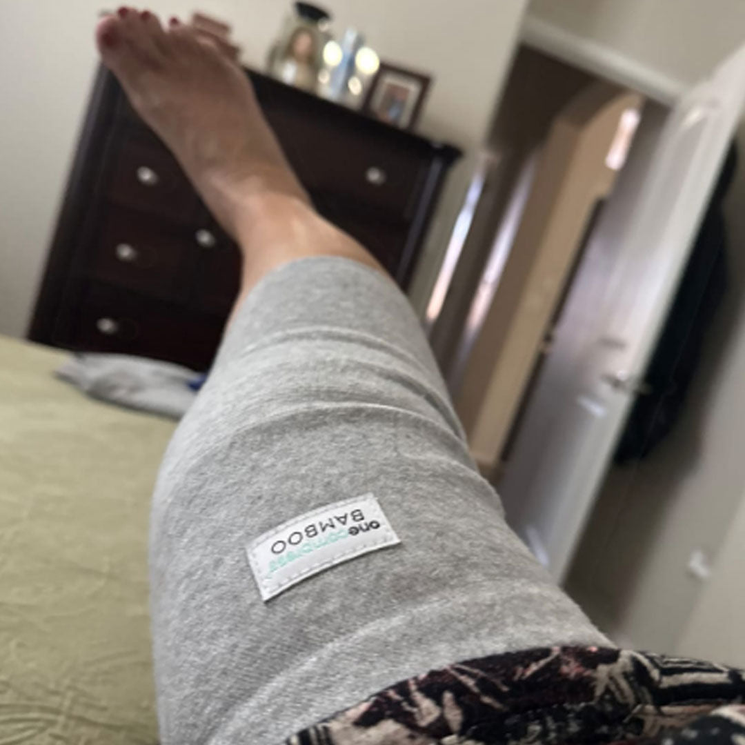 Person wearing a grey compression knee sleeve for pain relief, support, and improved circulation while staying active.